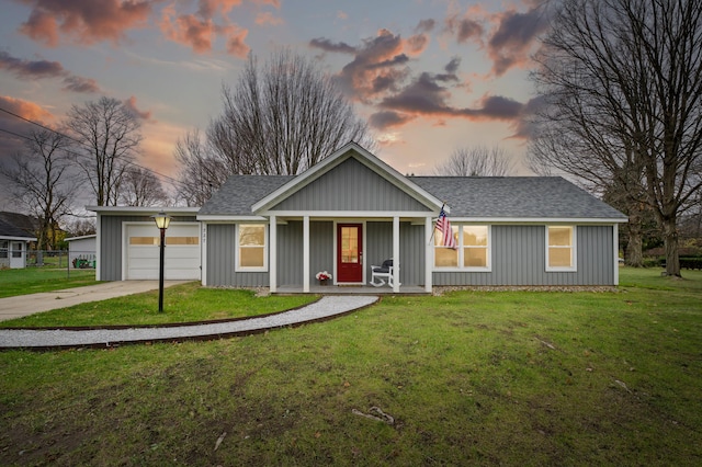 view of front of home with a lawn, covered porch, and a garage