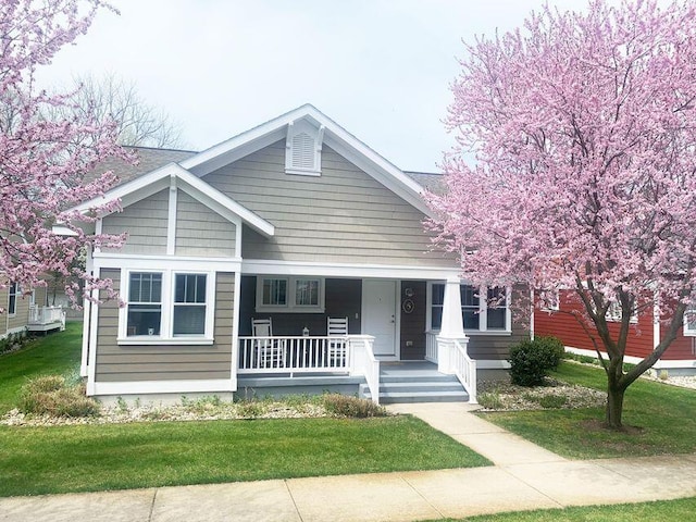 bungalow-style home featuring a porch and a front yard