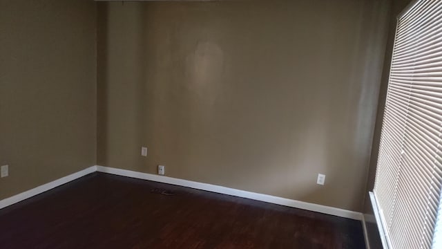 spare room featuring dark wood-type flooring