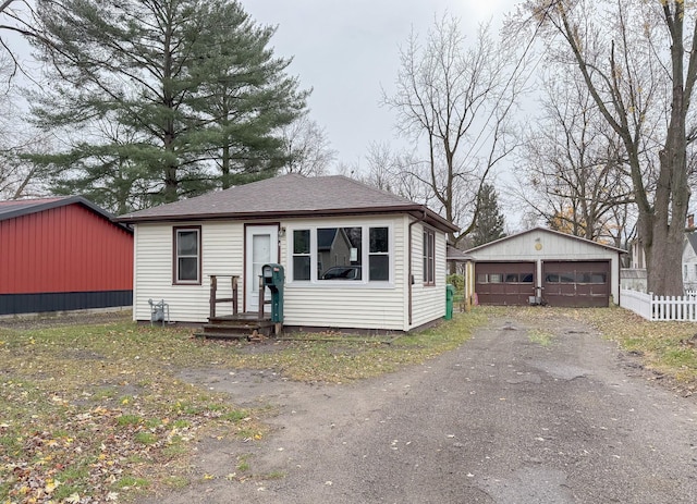 bungalow-style house with a garage and an outdoor structure