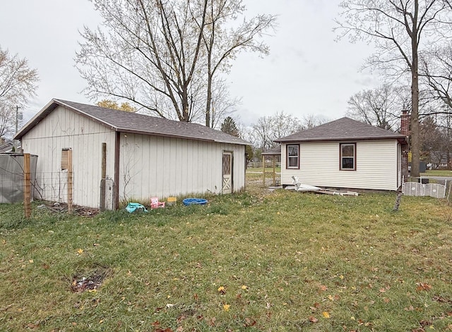 view of home's exterior with a lawn and an outbuilding