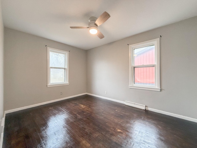 empty room featuring dark hardwood / wood-style flooring, a wealth of natural light, and ceiling fan