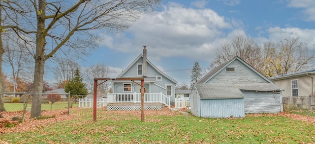 back of house featuring a shed and a lawn