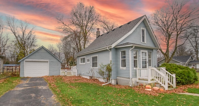 view of front of property with a lawn, an outbuilding, and a garage