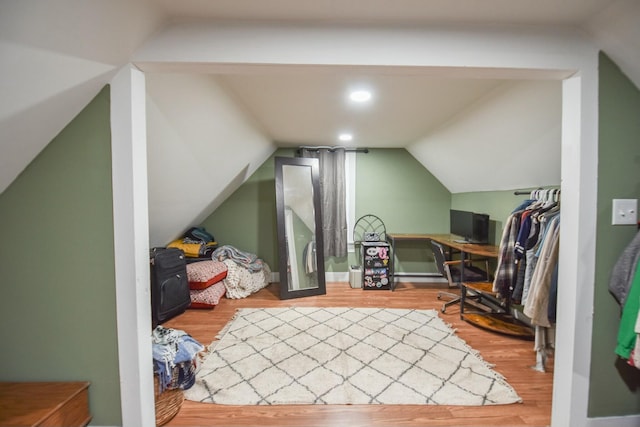 additional living space with wood-type flooring and vaulted ceiling