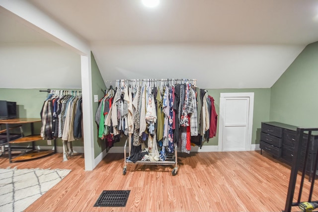 walk in closet featuring wood-type flooring and vaulted ceiling