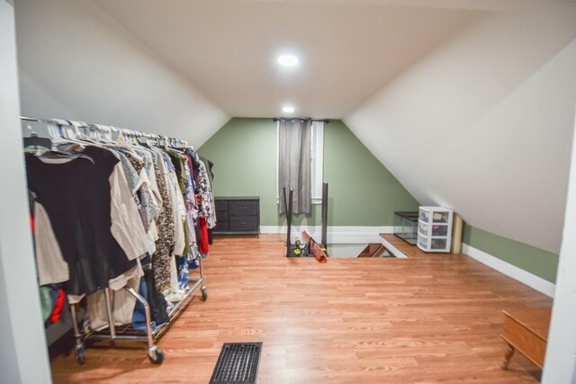 walk in closet with hardwood / wood-style flooring and lofted ceiling