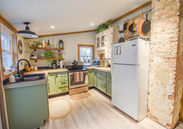 kitchen featuring crown molding, sink, green cabinetry, appliances with stainless steel finishes, and light hardwood / wood-style floors