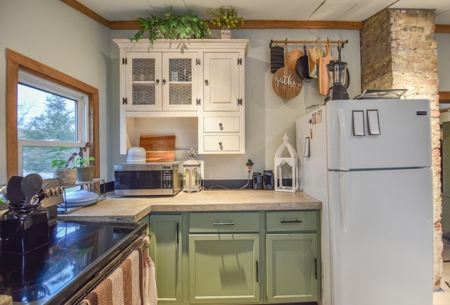 kitchen featuring white refrigerator, crown molding, green cabinetry, black range with electric cooktop, and white cabinetry