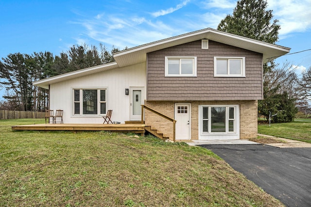 view of front facade with a front lawn and a wooden deck