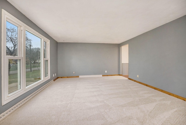 carpeted spare room featuring a baseboard heating unit