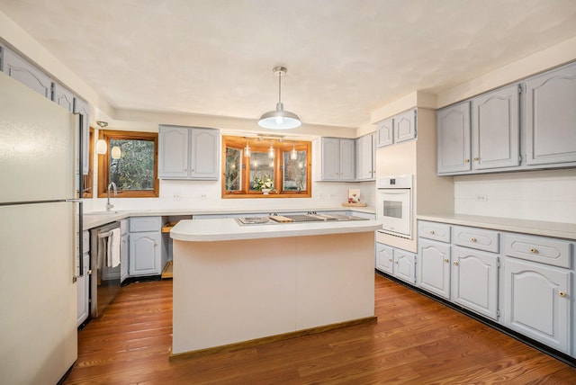 kitchen featuring dark hardwood / wood-style flooring, a center island, gray cabinets, and appliances with stainless steel finishes