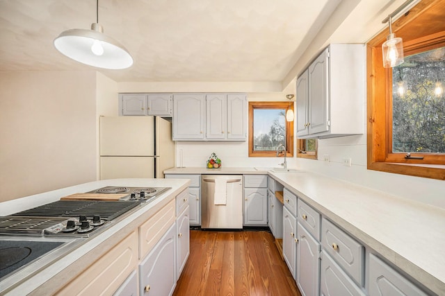 kitchen featuring hardwood / wood-style floors, hanging light fixtures, stainless steel appliances, and sink