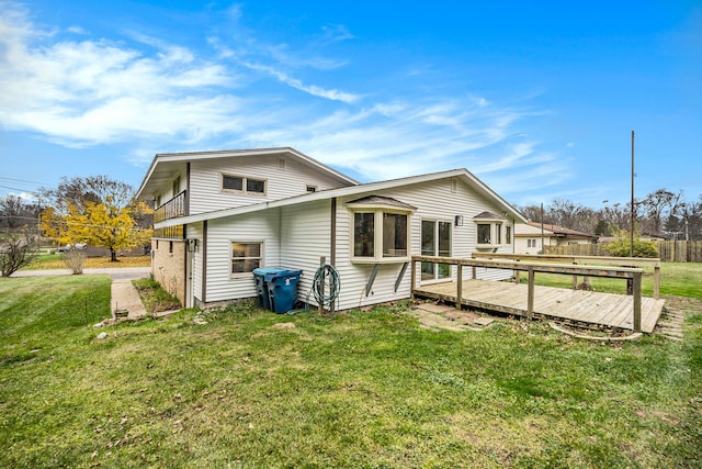 back of property featuring a lawn and a wooden deck