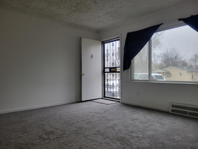 spare room featuring carpet and a textured ceiling