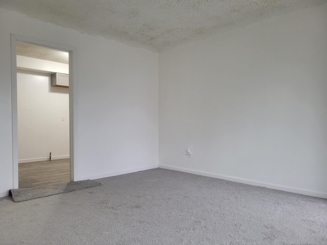 carpeted empty room with a textured ceiling