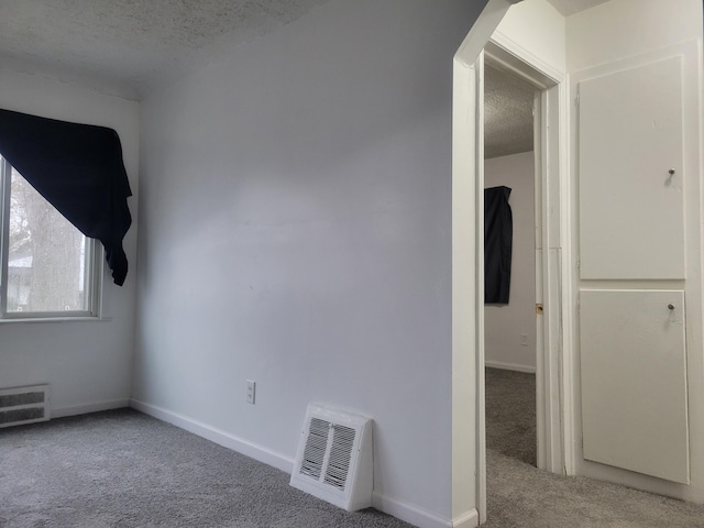 carpeted spare room with a textured ceiling