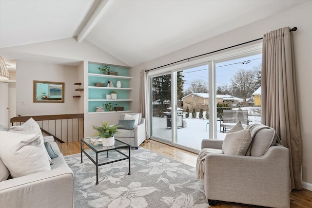 living room with vaulted ceiling with beams and light wood-type flooring