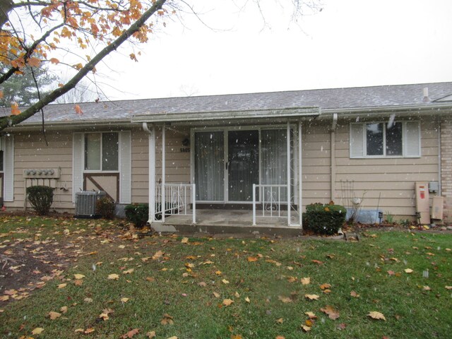 exterior space with cooling unit and a front lawn