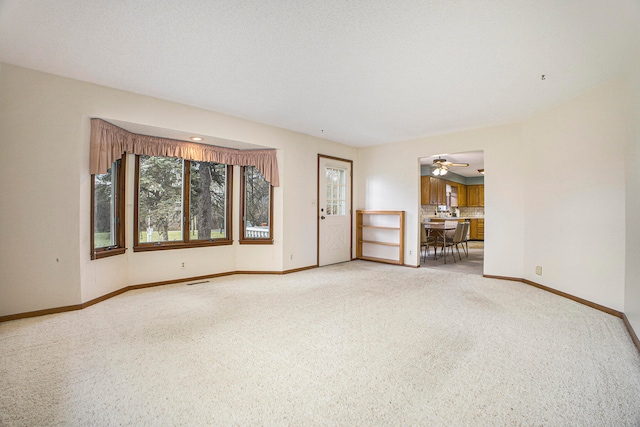 unfurnished living room with carpet floors and ceiling fan