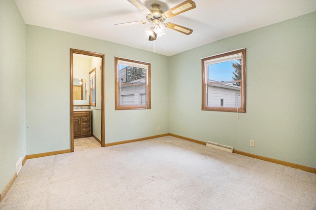 unfurnished bedroom featuring ceiling fan, light colored carpet, connected bathroom, and multiple windows