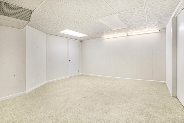 basement featuring carpet floors and a paneled ceiling