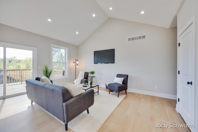 living room featuring light wood-type flooring and high vaulted ceiling