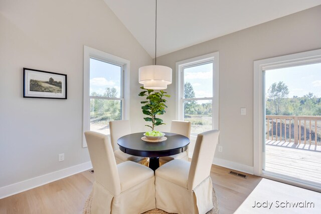 dining space featuring light hardwood / wood-style floors and vaulted ceiling