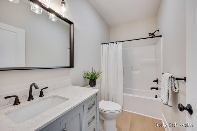 full bathroom featuring vanity, wood-type flooring, shower / tub combo, and toilet