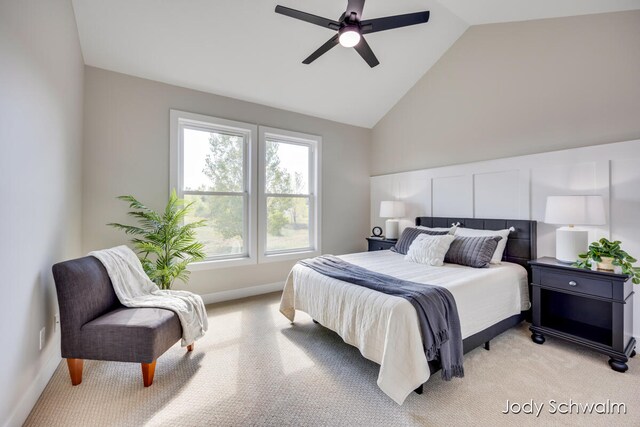 bedroom with ceiling fan, high vaulted ceiling, and light carpet