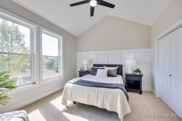 carpeted bedroom with ceiling fan, vaulted ceiling, and a closet