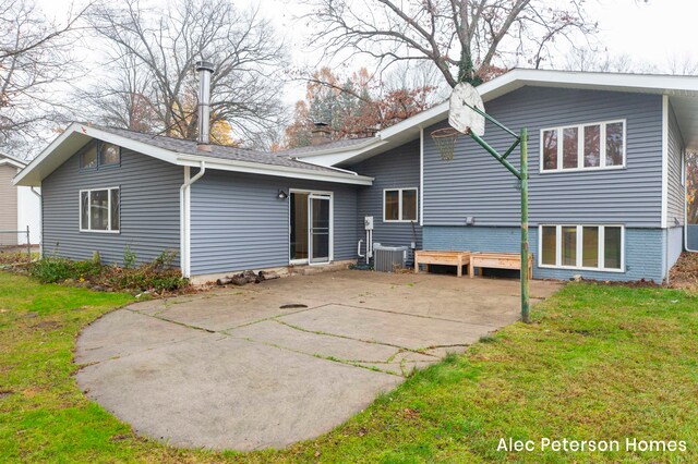 back of house featuring central AC unit, a patio area, and a lawn