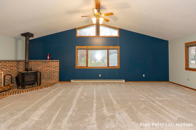 unfurnished living room featuring carpet, lofted ceiling, a wood stove, a baseboard heating unit, and ceiling fan