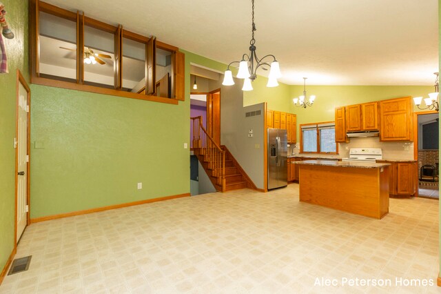 kitchen with stainless steel refrigerator with ice dispenser, white range oven, lofted ceiling, decorative light fixtures, and a kitchen island