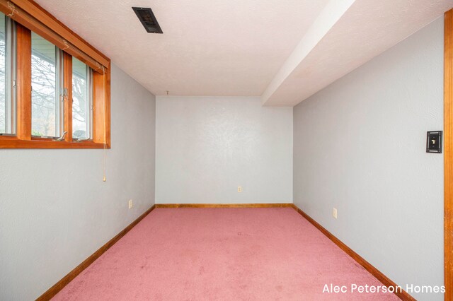 carpeted empty room with a textured ceiling