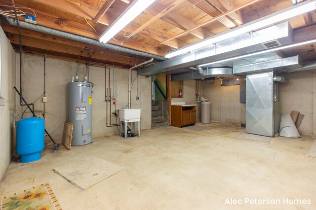 basement featuring electric panel, electric water heater, heating unit, and sink