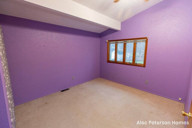 carpeted spare room featuring beam ceiling