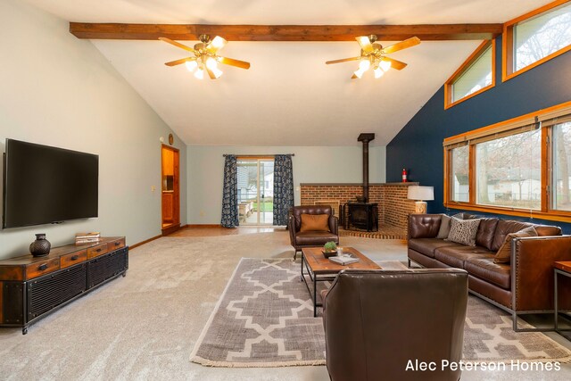 carpeted living room with beamed ceiling, high vaulted ceiling, a wood stove, and ceiling fan