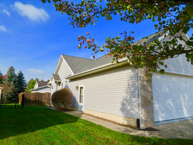 view of side of home with a yard and a garage