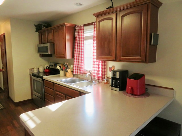 kitchen with sink, stainless steel appliances, and dark wood-type flooring