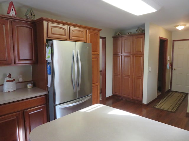 kitchen with stainless steel fridge and dark wood-type flooring