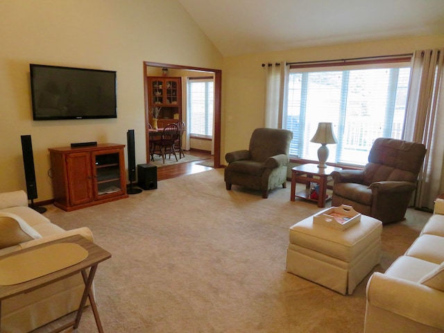 living room with light colored carpet, plenty of natural light, and lofted ceiling