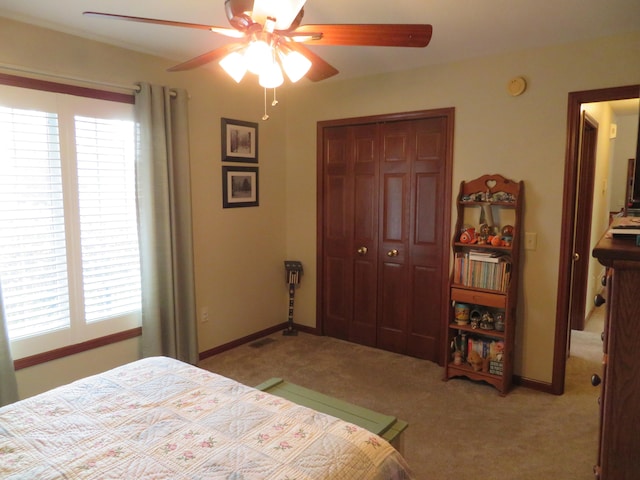 bedroom with a closet, light colored carpet, and ceiling fan