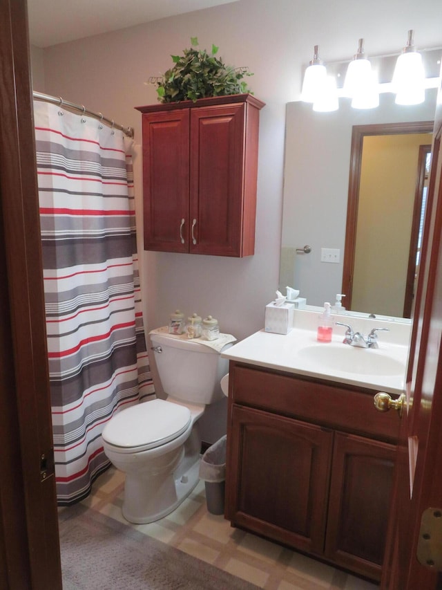 bathroom with vanity, toilet, and curtained shower