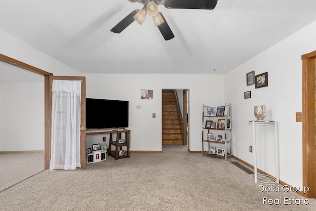 unfurnished living room with carpet flooring, ceiling fan, and a textured ceiling