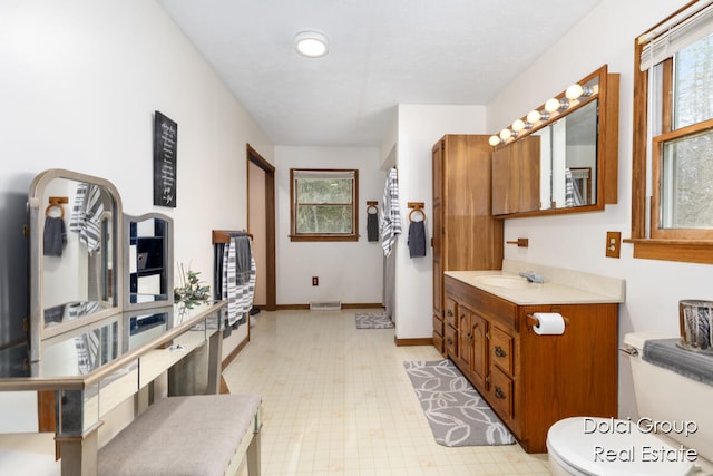 bathroom featuring plenty of natural light, toilet, and vanity