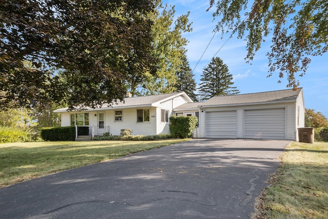 ranch-style home with a garage and a front lawn