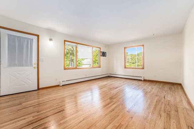 spare room featuring a baseboard radiator and light hardwood / wood-style flooring