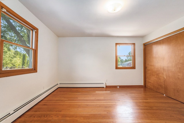 interior space featuring plenty of natural light, light wood-type flooring, and a baseboard radiator