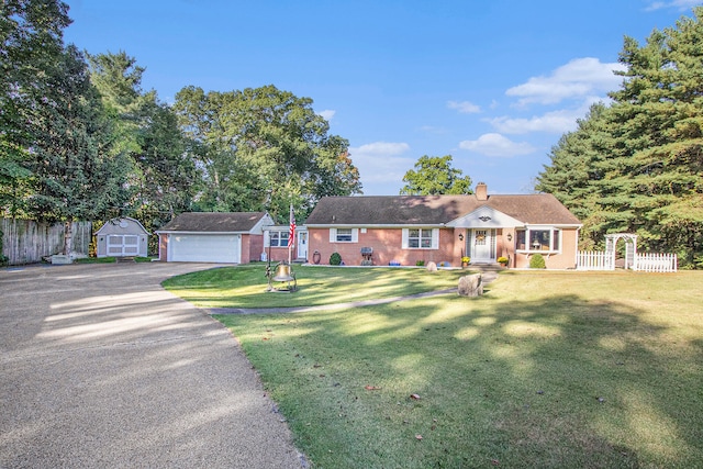 ranch-style home featuring an outbuilding, a front lawn, and a garage